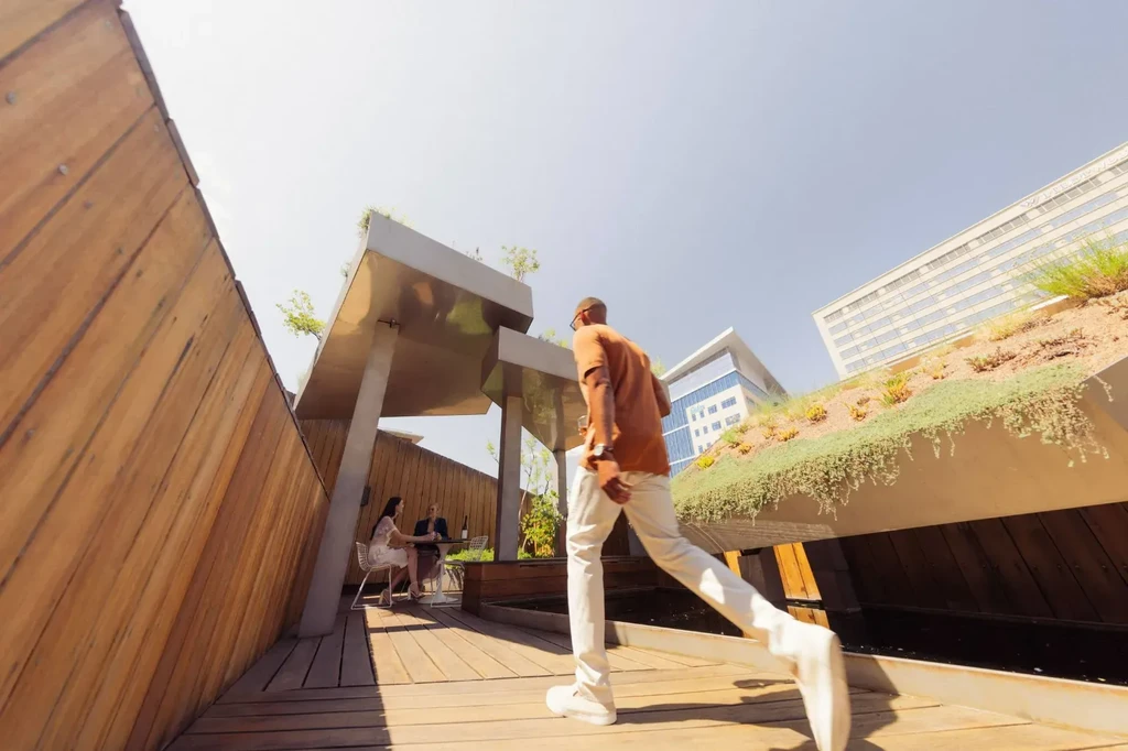 Outdoor modern architectural space with angular canopy and people dining.