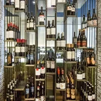 Multi-tiered display of wine bottles on modern, illuminated shelving.