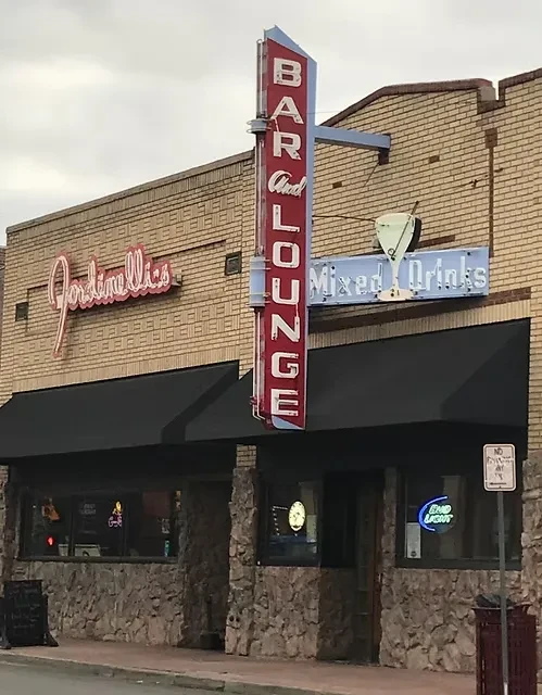 Street view of Jordinellis Bar and Lounge with glowing neon signs.