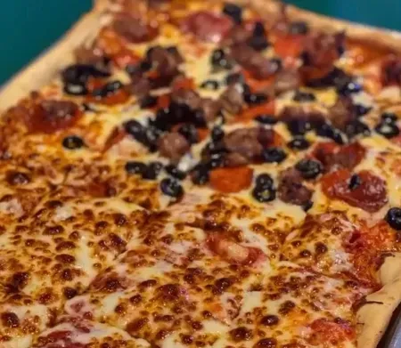 Close-up, overhead pizza: half cheese, half olives and meat.