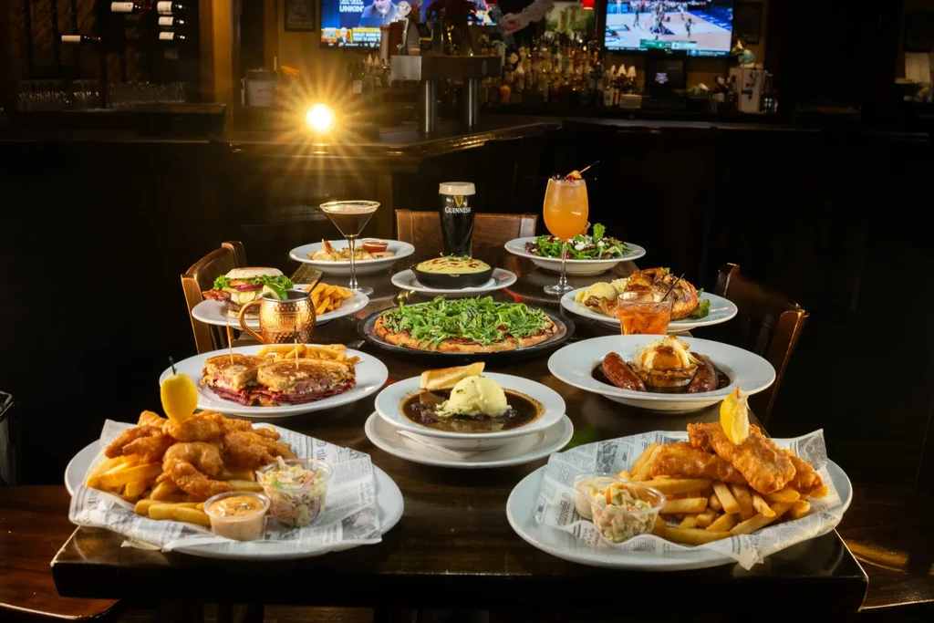 Variety of pub food and drinks on a dark restaurant table.