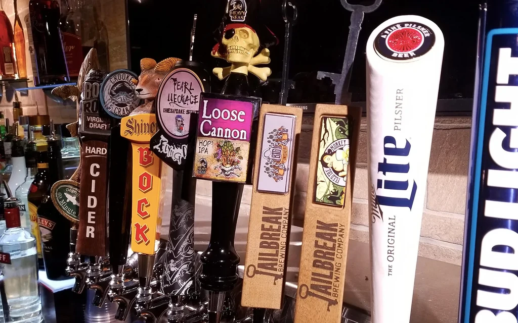 Close-up of ten distinct branded beer and cider tap handles.