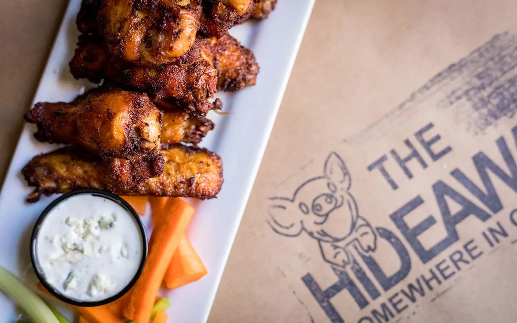 Crispy golden-brown chicken wings with blue cheese dip, carrots, and celery.
