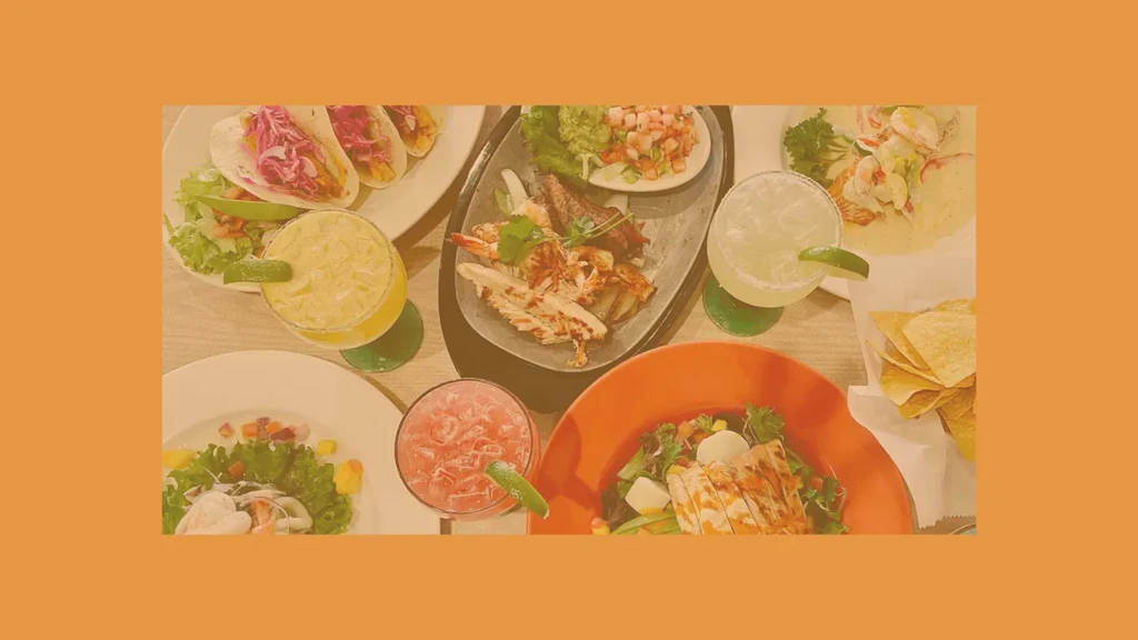 Overhead shot of a table filled with diverse Mexican food and drinks.