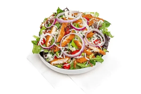 Fried chicken salad with lettuce, tomatoes, bacon, cheese, and dressing.