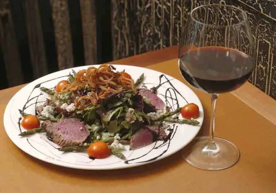 Steak salad with blue cheese, asparagus, tomatoes, crispy onions, red wine.