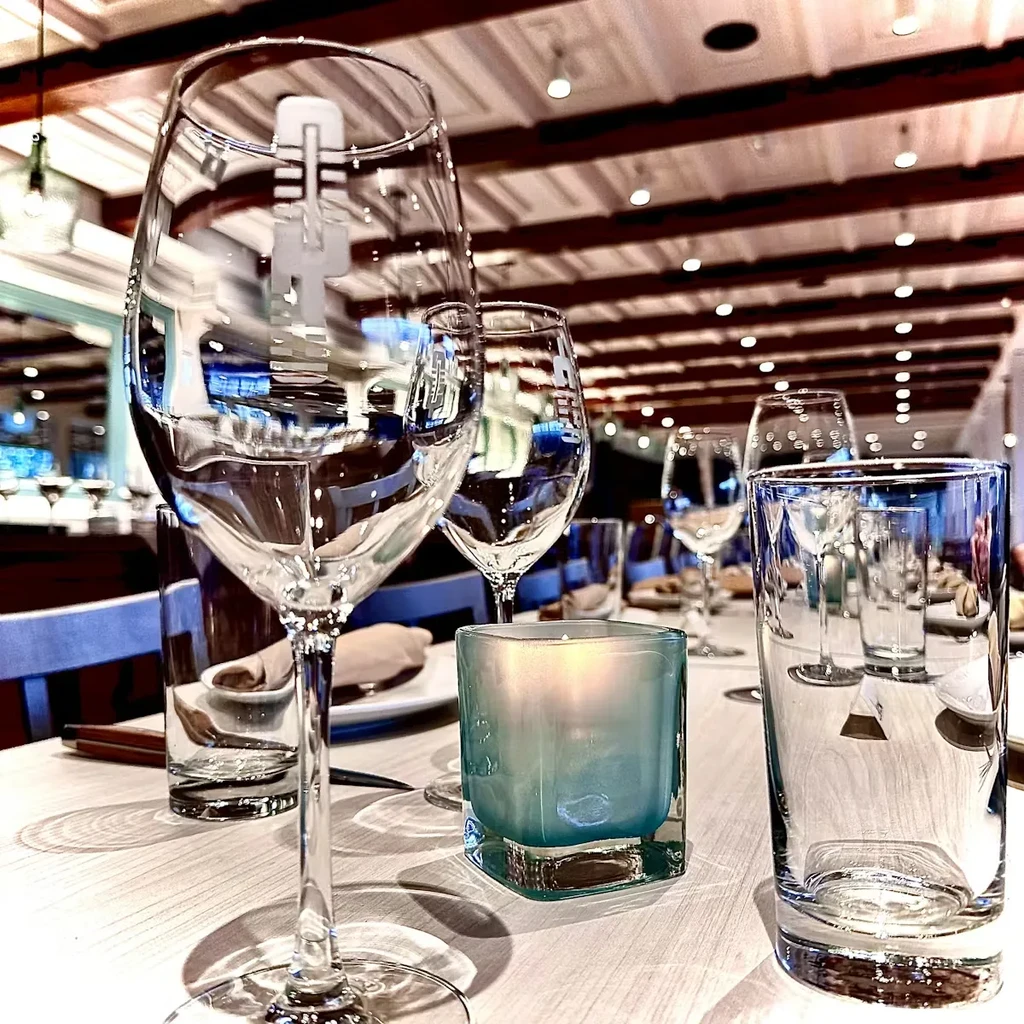 Elegant restaurant table set with empty glasses and a lit candle.