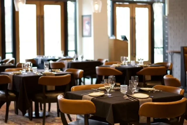 Elegant, empty restaurant dining room with meticulously set tables.
