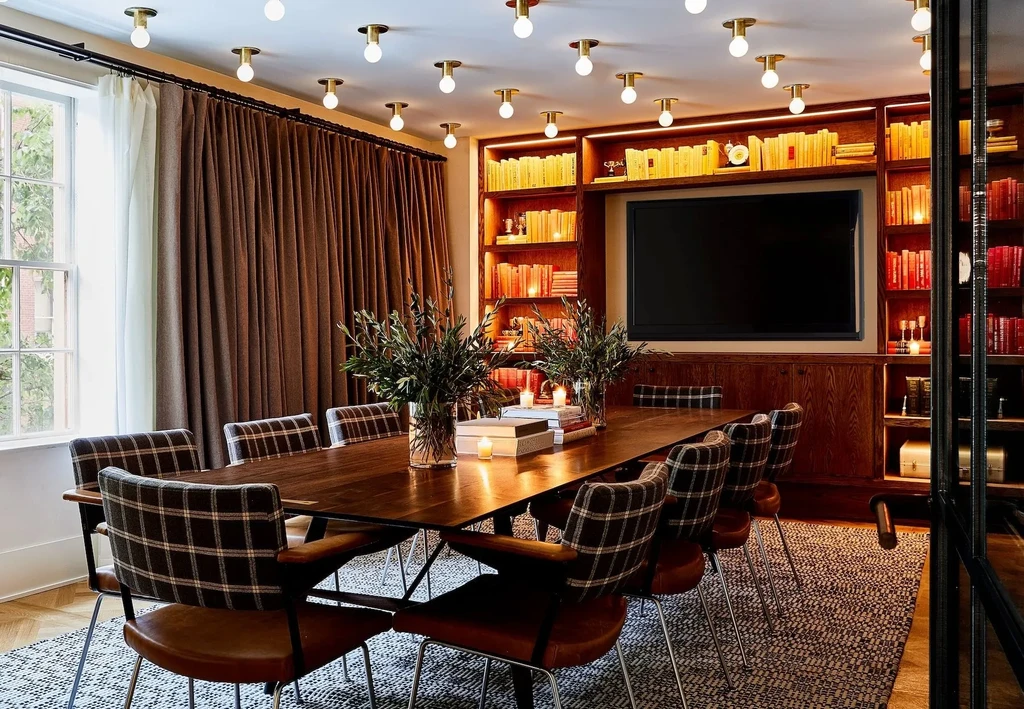 Private dining room with long wooden table, plaid chairs, and built-in bookshelf.