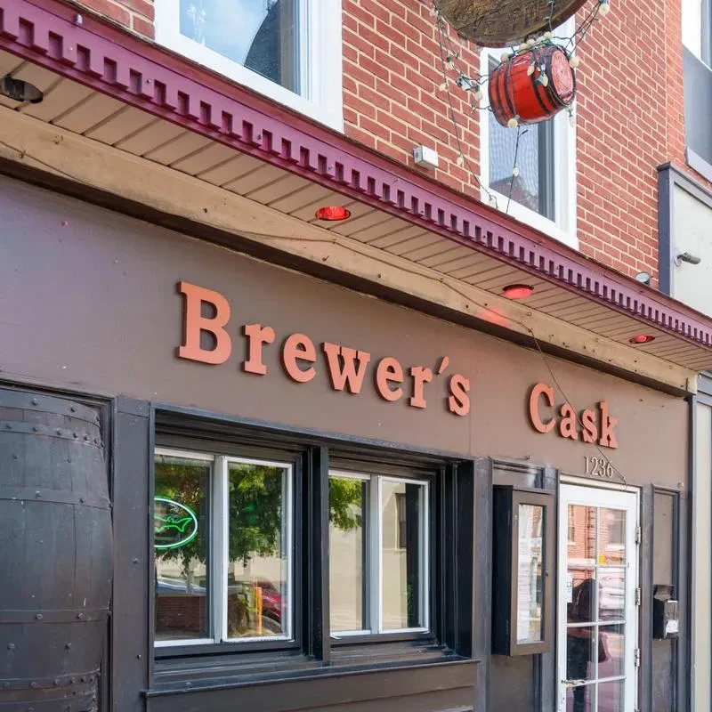 Brewer's Cask bar exterior with prominent barrels, brick, and signage.