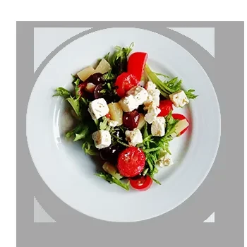 Colorful salad with greens, tomatoes, feta, grapes, and fruit on a white plate.