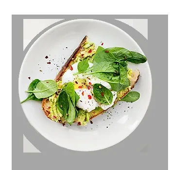 Vibrant green avocado toast topped with two poached eggs and spinach.