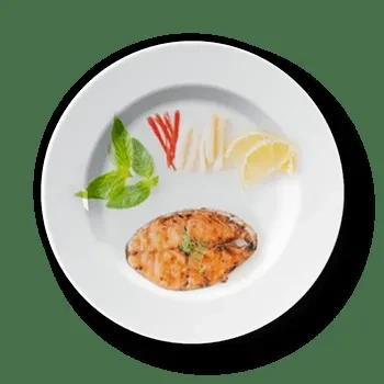 Grilled fish fillet with dill, mint, chili, and lemon on a white plate.