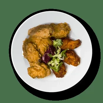 White plate holds fried and buffalo chicken wings with a lettuce garnish.