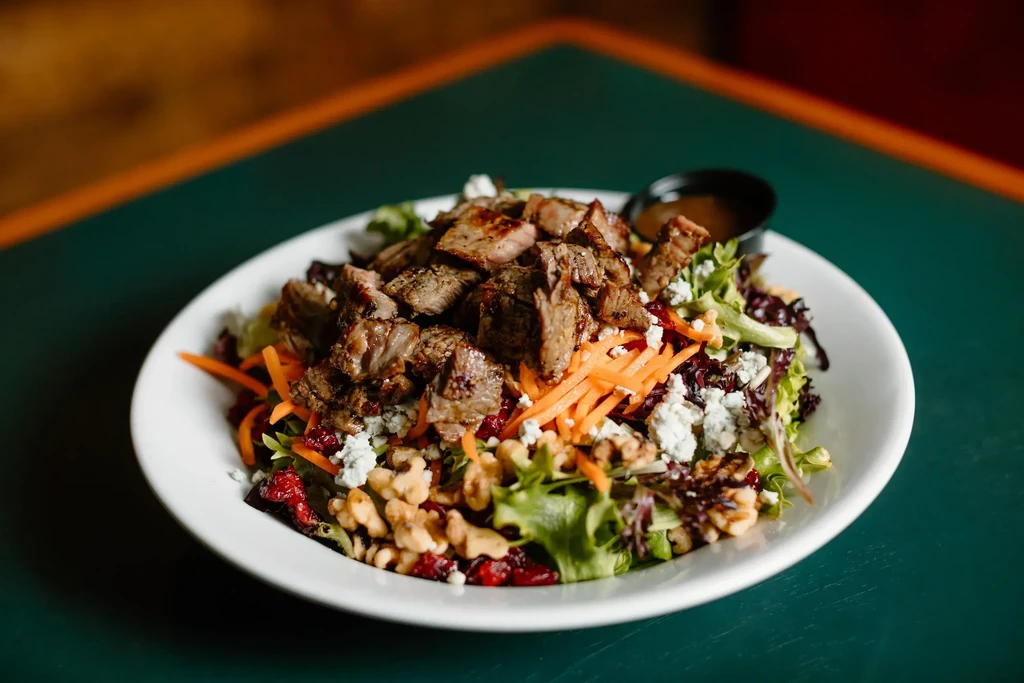 Salad with grilled meat, mixed greens, carrots, blue cheese, walnuts, cranberries.