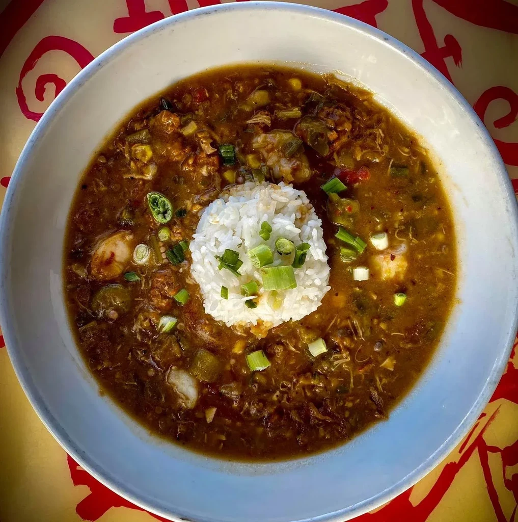Top-down gumbo with rice, seafood, okra, and green onions.