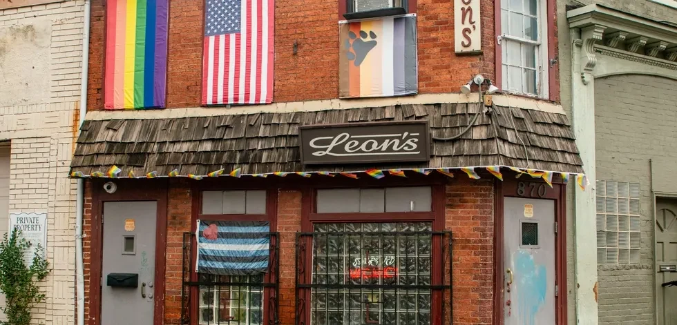 Leon's corner brick building with multiple pride flags and an awning.
