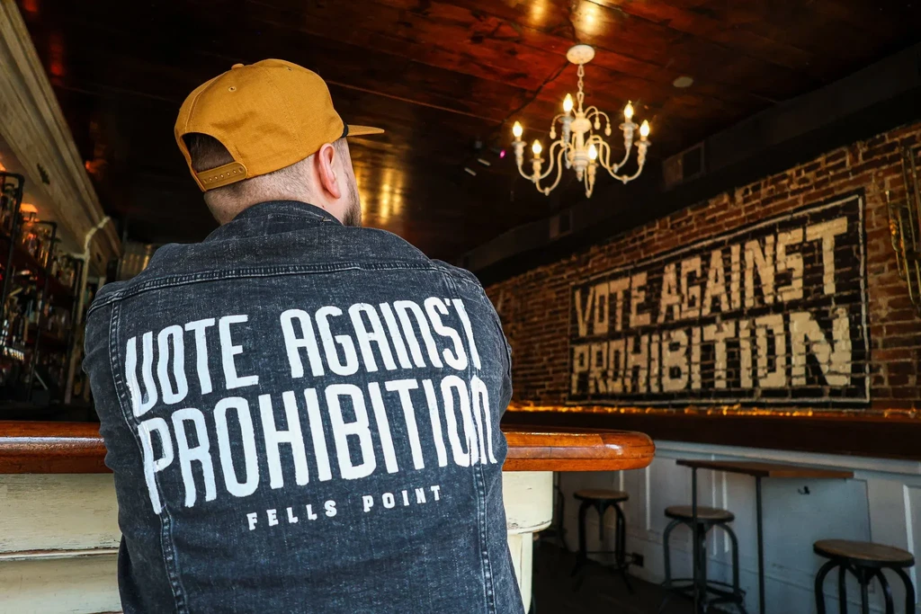 Back of person at bar with 'VOTE AGAINST PROHIBITION' signs.