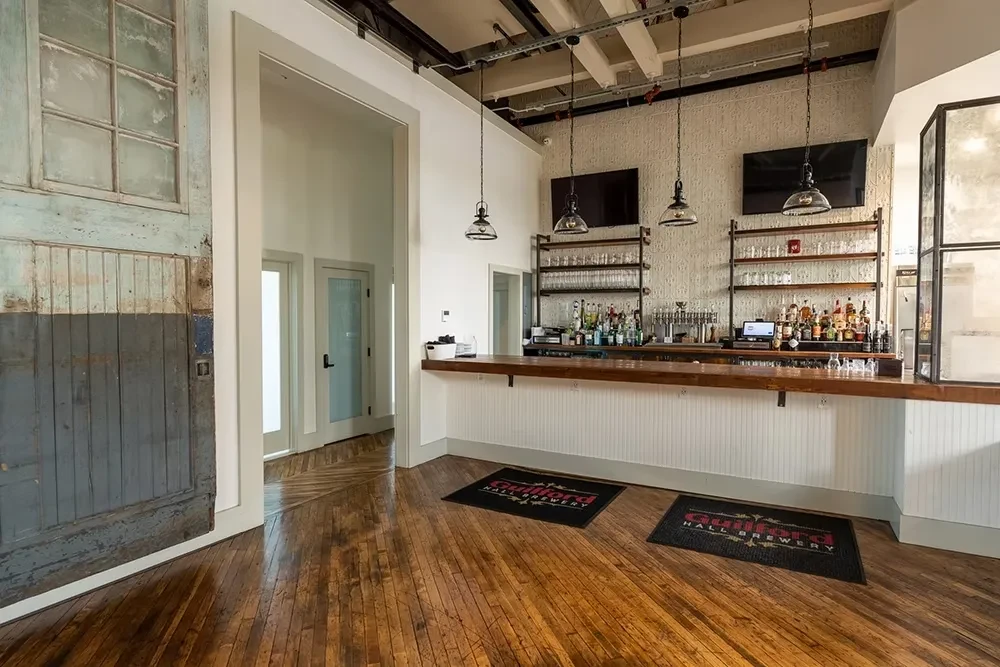 Guilford Hall Brewery's empty industrial bar with bottles and taps.