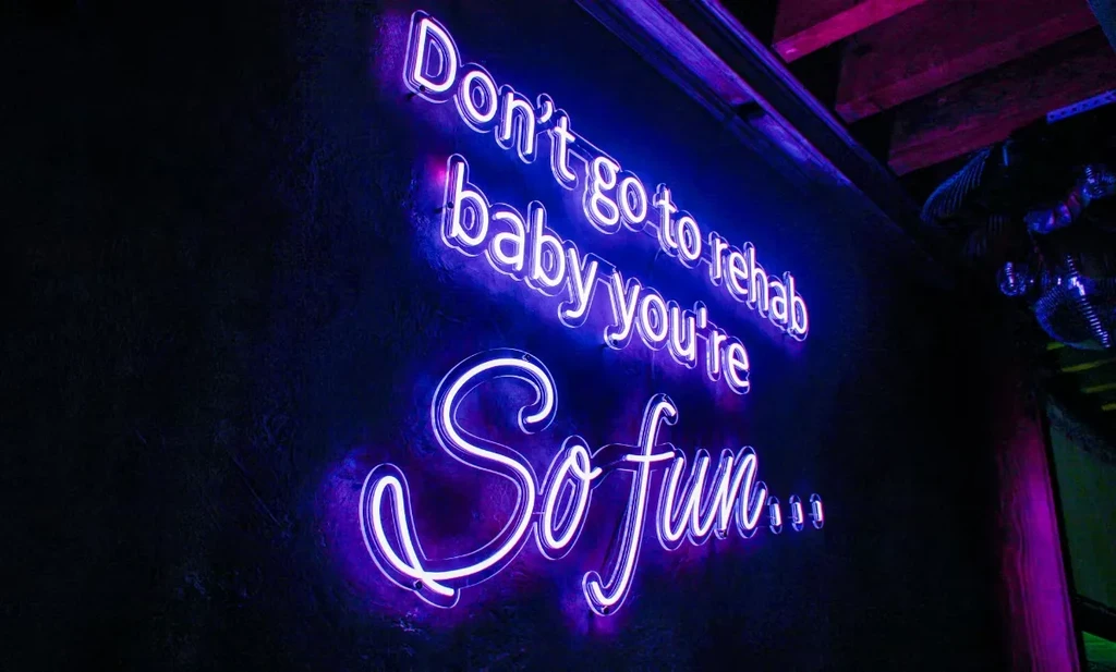 Purple and white neon sign: Don't go to rehab baby you're So fun...