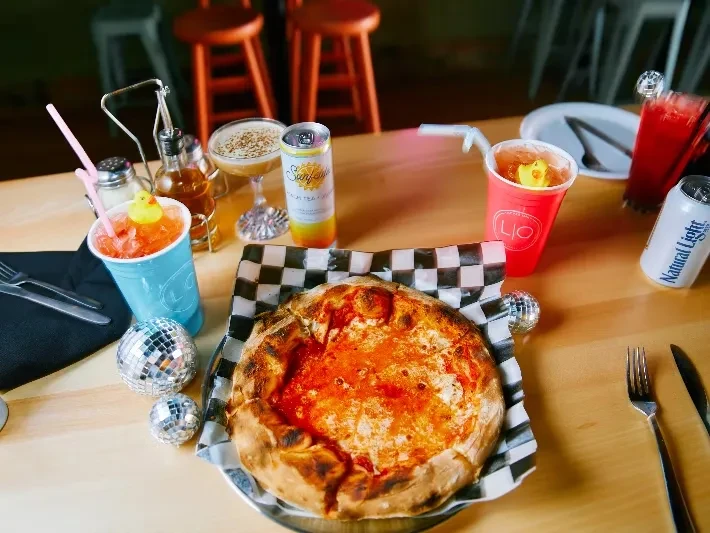 Cheese pizza, varied drinks, and disco balls on a casual restaurant table.
