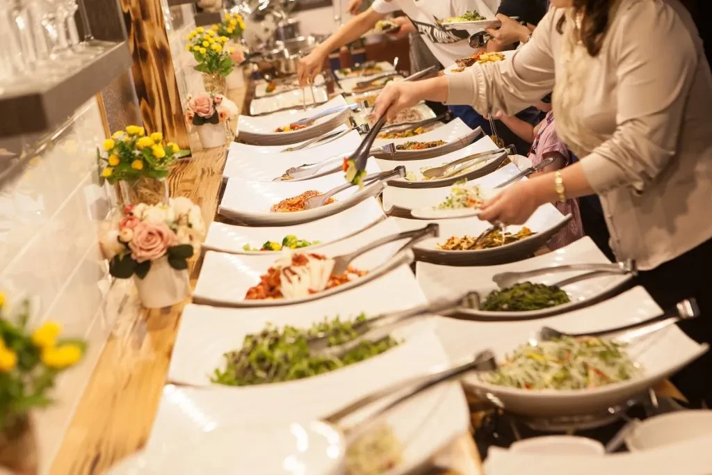 People serving themselves from a vibrant, well-presented buffet line.