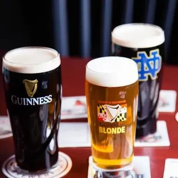 Three beers: Guinness, Brewer's Art Blonde, and dark beer with ND logo.