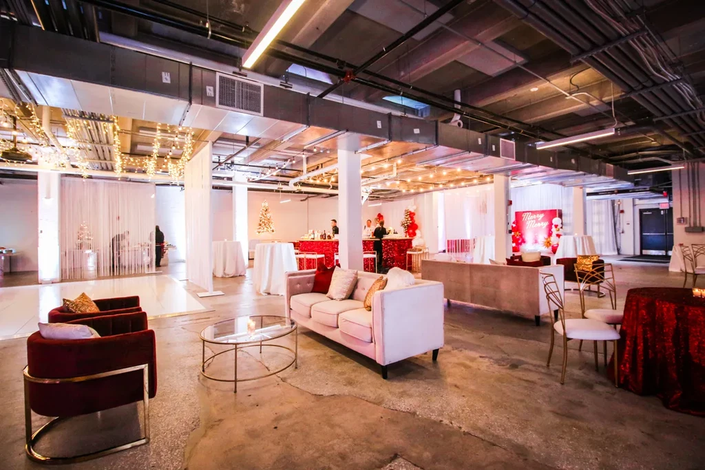 Industrial-chic event hall with lounge, sequin bar, and holiday decorations.