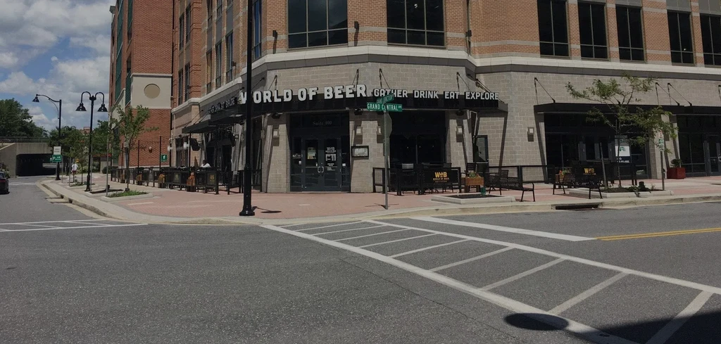 World of Beer restaurant with patio on a sunny urban street corner.