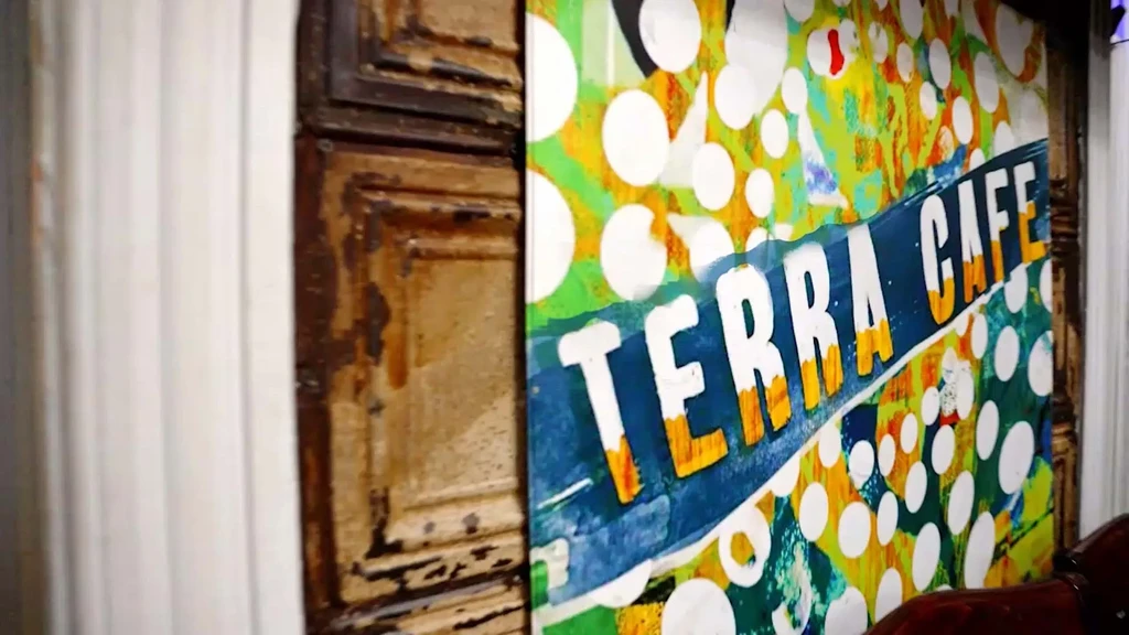 Abstract TERRA CAFE sign with green, yellow, blue, and polka dots.