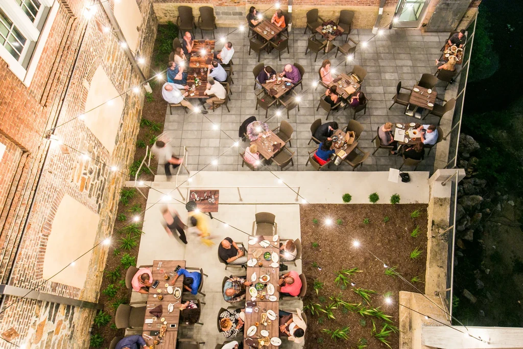 Aerial view of illuminated restaurant patio at night with diners.