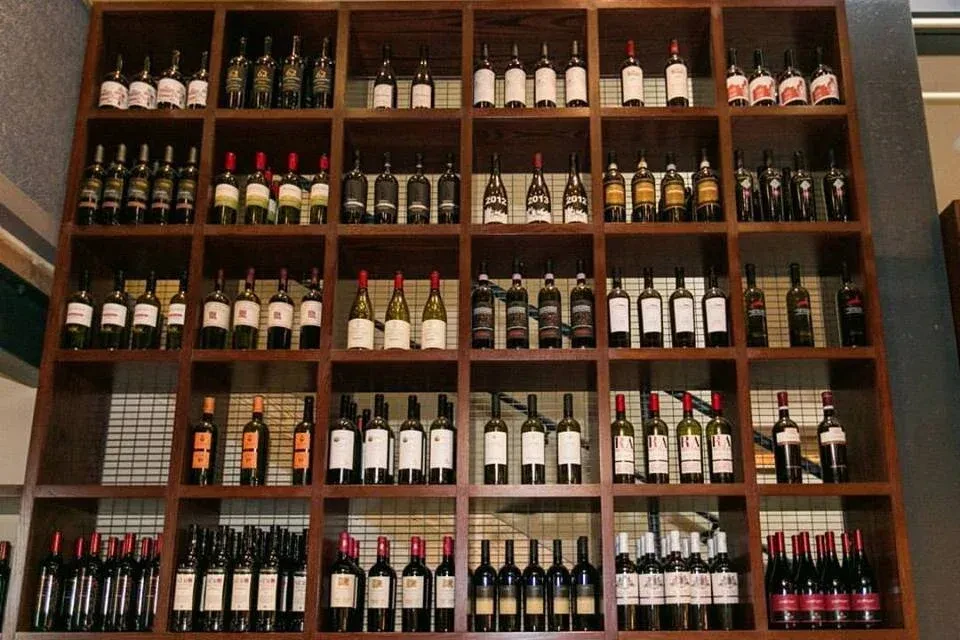Floor-to-ceiling wooden wine rack filled with numerous bottles of wine.