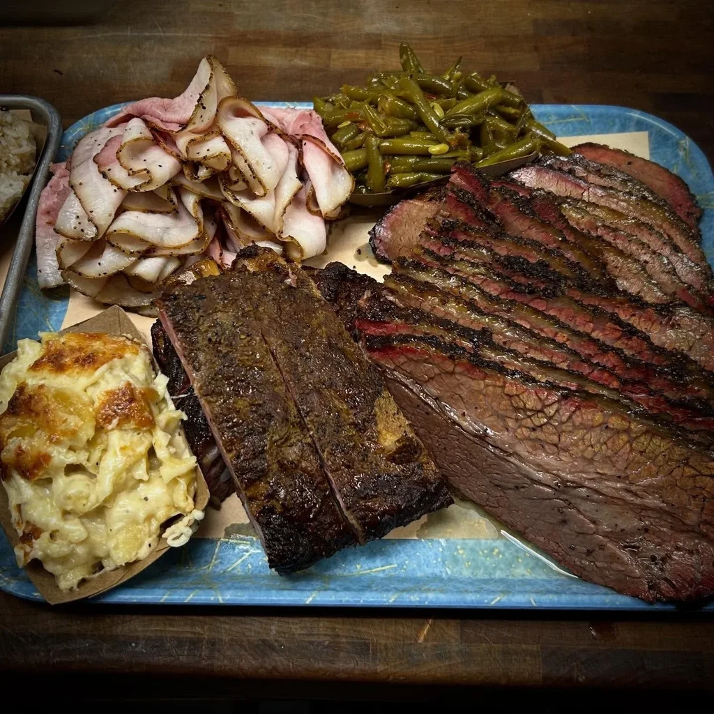 Barbecue platter with brisket, ribs, turkey, mac and cheese, green beans.