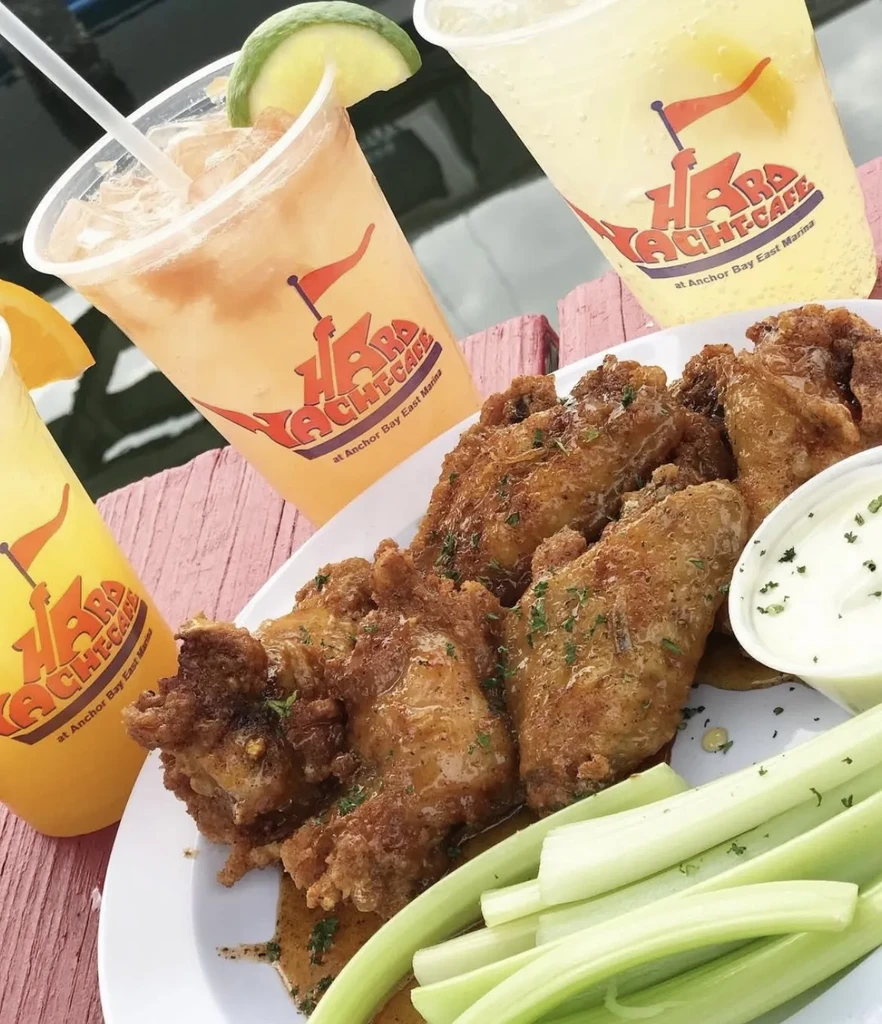 Crispy chicken wings, sauce, celery, and drinks from Hard Yacht Cafe.