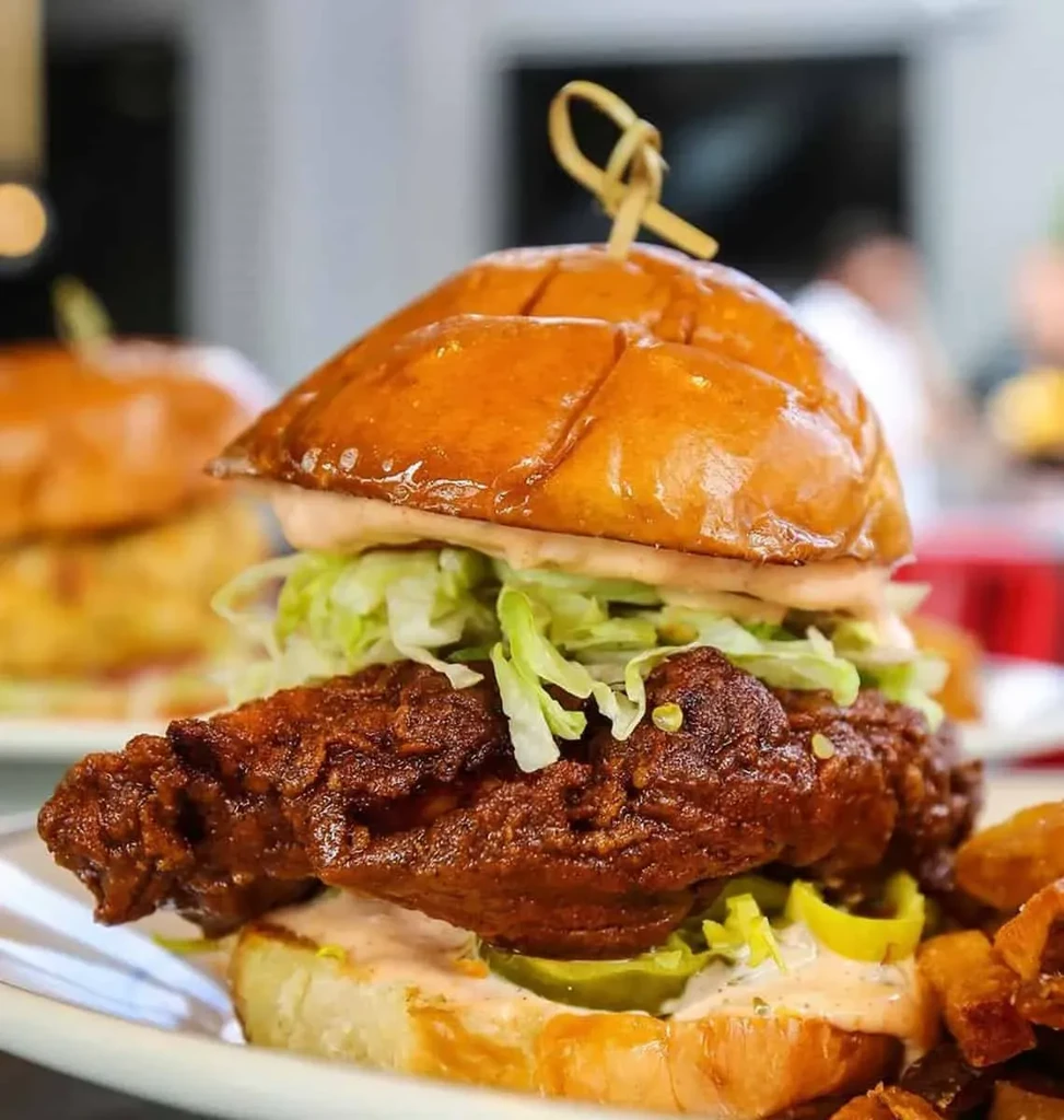 Crispy fried chicken sandwich with lettuce, pink sauce, and pickles.