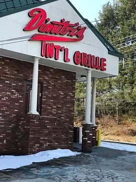 Dimitri's INT'L GRILLE building, brown bricks, red/white sign, melting snow.