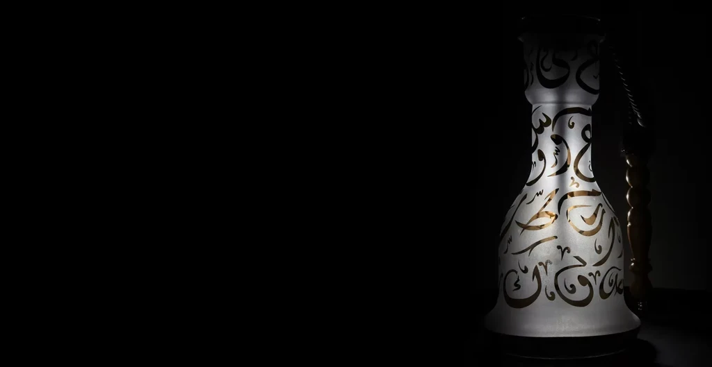 Frosted glass hookah base with glowing gold Arabic calligraphy.
