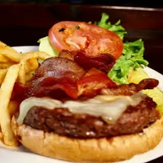 Toasted burger with bacon, melted cheese, lettuce, tomato, and golden fries.
