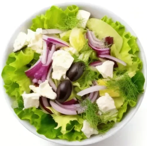 Overhead view of lettuce salad with red onion, feta, olives.