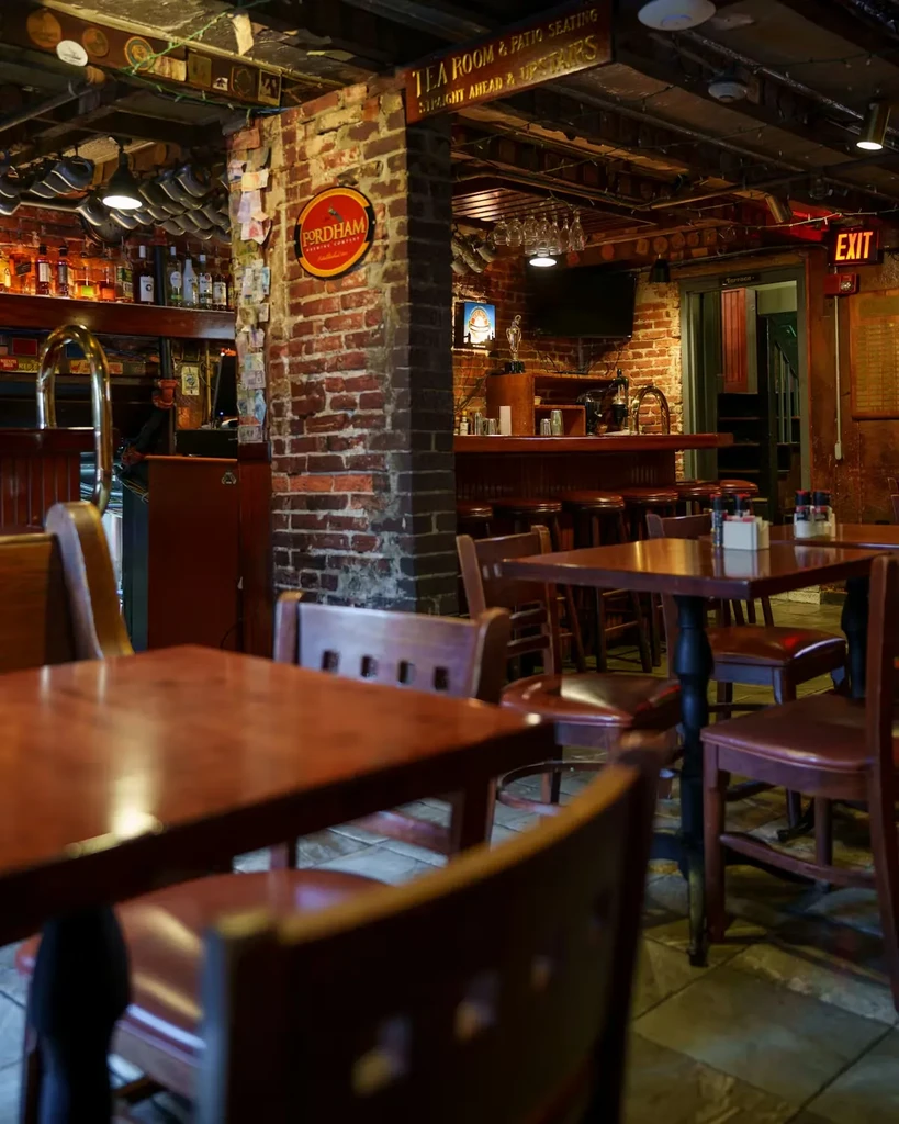 Warm, rustic restaurant interior with brick pillar and stocked bar.