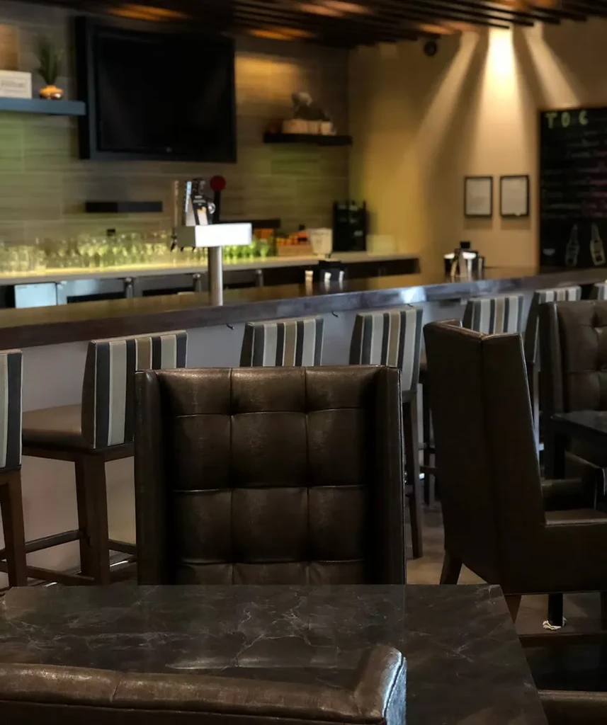 Sophisticated empty bar interior with plush seating and striped stools.