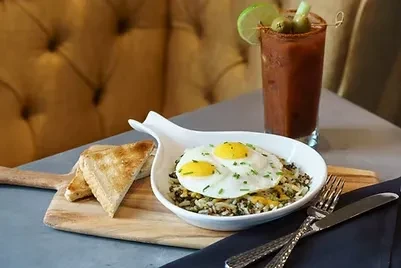 Fried eggs with chives, greens, toast, and Bloody Mary cocktail.