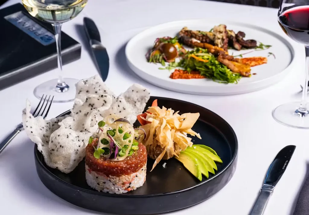 Tuna tartare and grilled octopus dishes elegantly plated in an upscale restaurant.