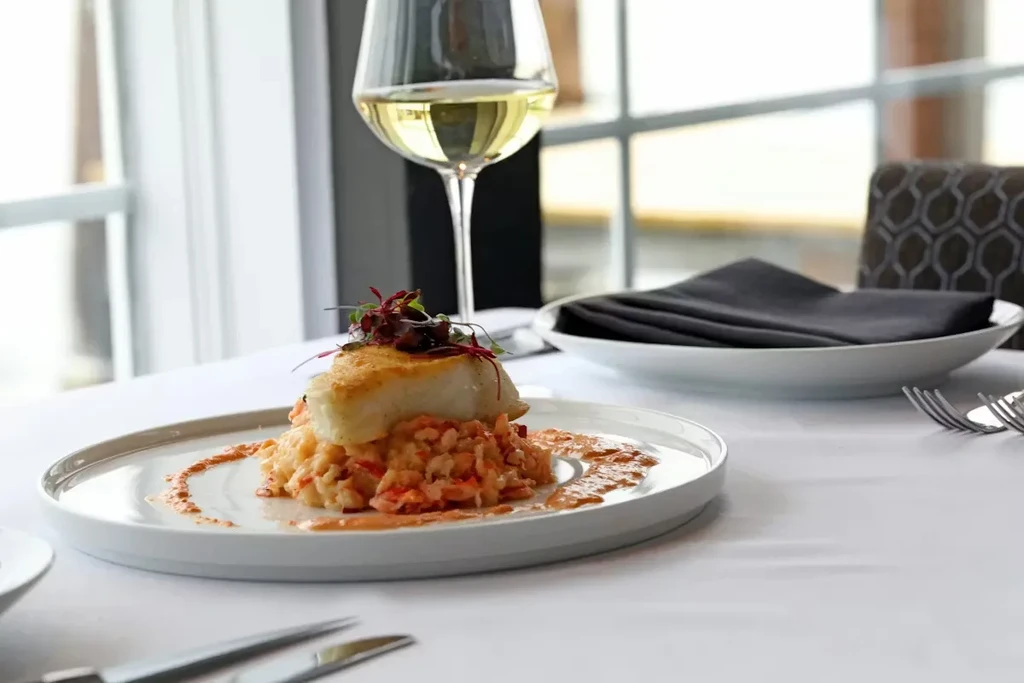 Seared fish on creamy risotto with microgreens in a restaurant.