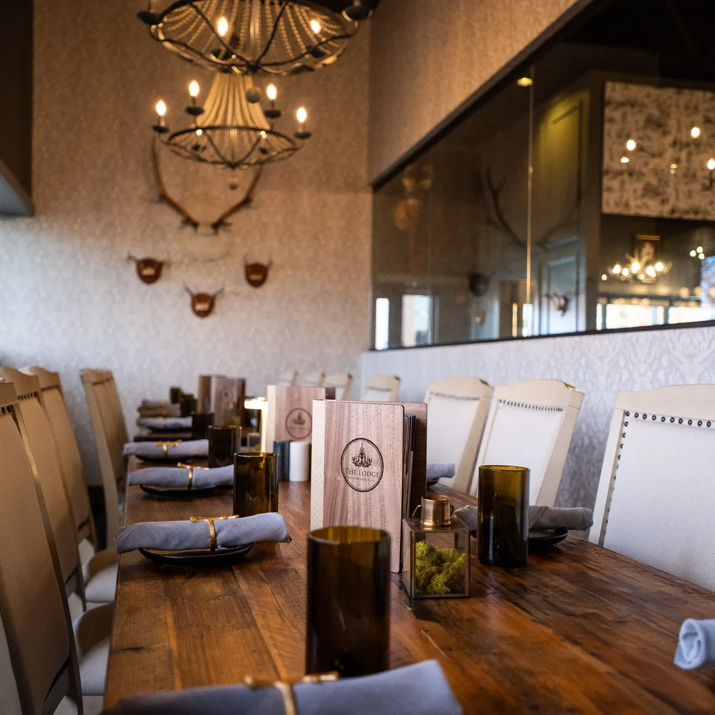 A well-appointed lodge restaurant interior with a rustic dining table, warm lighting.