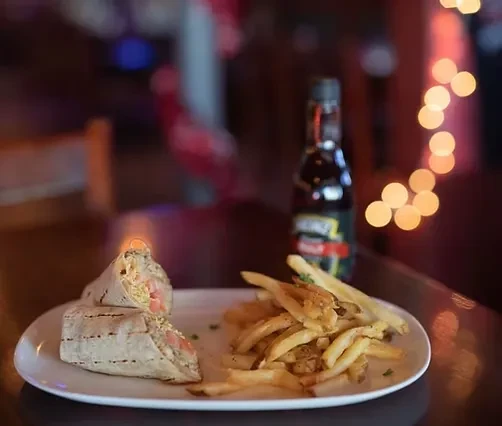 White plate with a cut burrito, french fries, and Heinz ketchup.