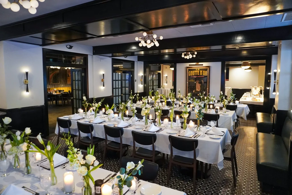 Elegant black and white dining room with long tables set for an event.