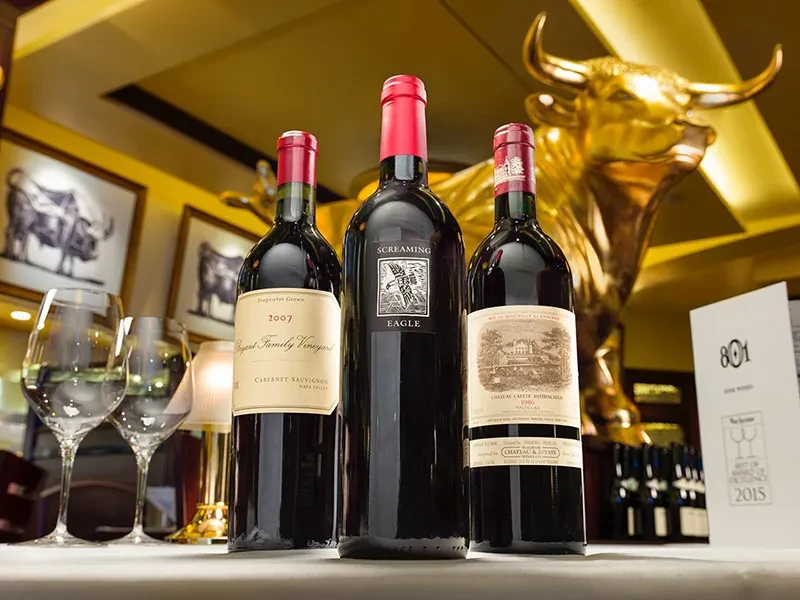Caymus, Screaming Eagle, Lafite Rothschild wines in a luxurious restaurant setting.