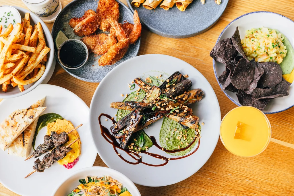 Overhead: Various artfully arranged foods and drinks on a wooden table.