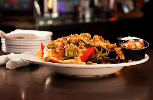 Loaded nachos with meat, melted cheese, jalapeños, and salsa.
